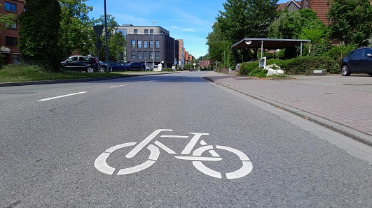 Piktogramm auf der Straße, das darauf hinweist, dass Radfahrende auch die Fahrbahn benutzen dürfen