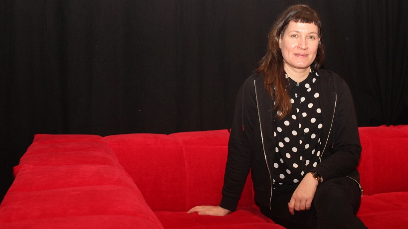 Mädchenpädagogik Mädchenpädagogin Catherine Bartl sitzt auf einer roten Couch © Hansestadt Stade