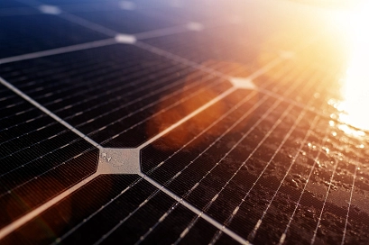 Zu sehen ist eine Detailaufnahme eines PV-Panels, das im Sonnenlicht glänzt